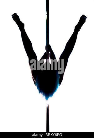 A person with blue hair is performing a pole dance, holding onto the pole with their hands and legs spread out. Stock Photo
