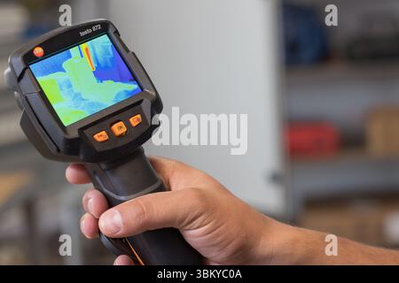 VINKOVCI, CROATIA, 06.20.2018:Hand holding a thermal imaging device to capture heat signatures in a room, showcasing technology used for heat diagnost Stock Photo