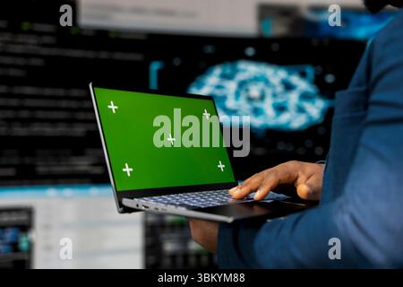 Young engineer works on binary code with copy space on laptop, reflecting the mindset of a tech world. Innovation hub with programming languages and development tools, coding life. Stock Photo