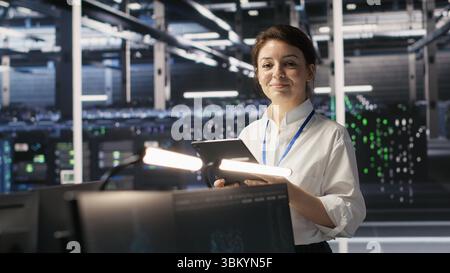 Data center team of technicians working on neural network software development. Server hub colleagues implementing deep learning artificial intelligence technology in workplace, camera A Stock Photo