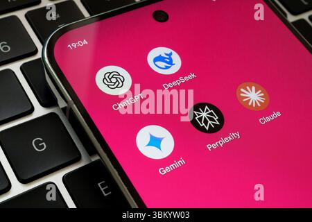 AI assistant app icons including ChatGPT, DeepSeek, Perplexity, Claude, and Gemini displayed on smartphone over keyboard. Stafford, United Kingdom, Ju Stock Photo