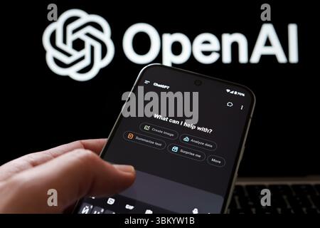 ChatGPT interface shown on smartphone held in hand with OpenAI branding in background. Stafford, United Kingdom, June 23, 2025 Stock Photo