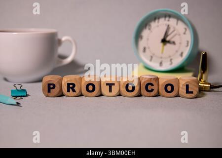 Text PROTOCOL is written on a folder lying on a stack of papers with a pen on the table. Business concept Stock Photo