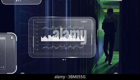 Standing Korean IT admin monitoring server racks in data center, with floating charts, copy space Stock Photo