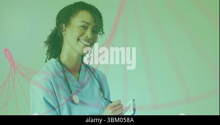 Standing female nurse taking notes in studio portrait, with clipboard and stethoscope Stock Photo