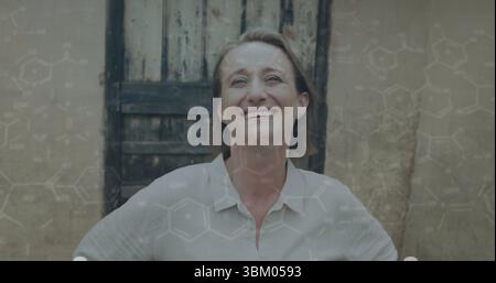 Smiling woman in collared shirt posing before wooden door and plaster wall, with chemical overlay Stock Photo