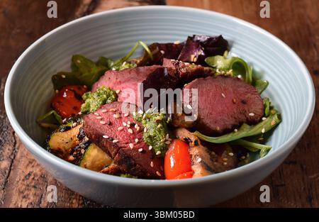 Bowl with warm sliced roast beef and grilled vegetables salad Stock Photo