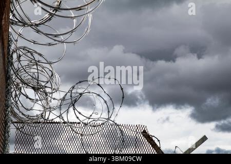 Barbed wire. Cloudy sky, dark storm clouds. Stock Photo