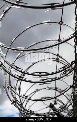 Barbed wire. Cloudy sky, dark storm clouds. Stock Photo
