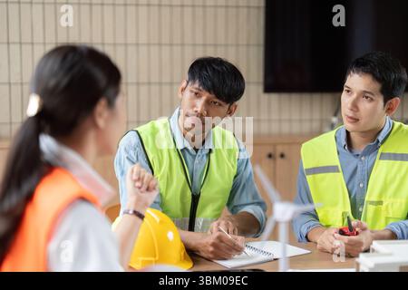 Sustainable Architecture Discussion. Engineers collaborating on eco-friendly construction strategies. Stock Photo