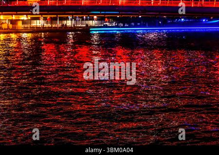 Colorful reflection illuminated Hai River, Tianjin, China. Hai River in Tianjin creates beautiful reflections abstracts. Stock Photo