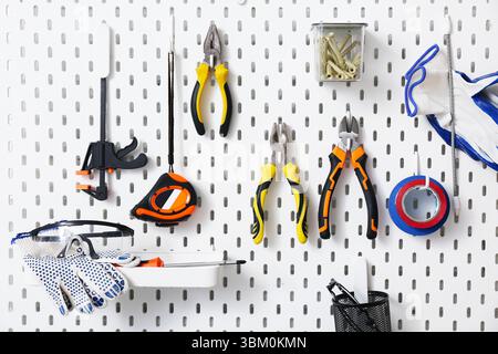 Working tools hanging on peg board Stock Photo