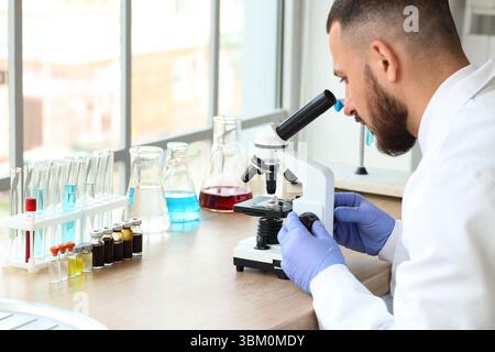 Male scientist looking through microscope in laboratory Stock Photo
