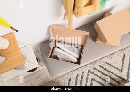 Shoe boxes with sneakers on soft bench in wardrobe, top view Stock Photo