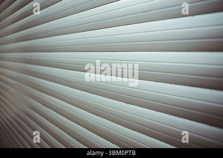 Metal rolling shutter door is filling frame in flat design with light grey horizontal slats Stock Photo
