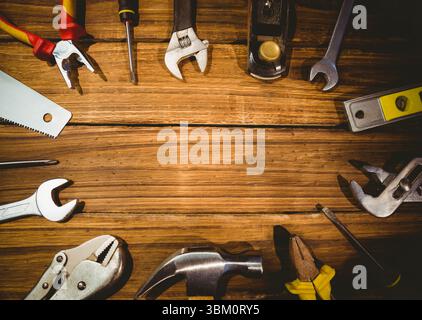 Assorted hand tools are lying on flat wooden tabletop in flat design, showing pliers and wrenches Stock Photo