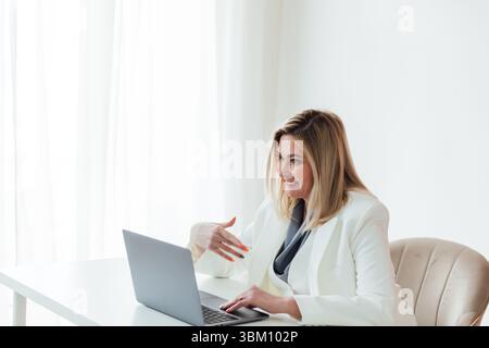 Woman in business suit working with online laptop in office Stock Photo