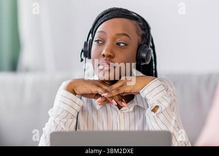Pensive black lady having online training at home Stock Photo
