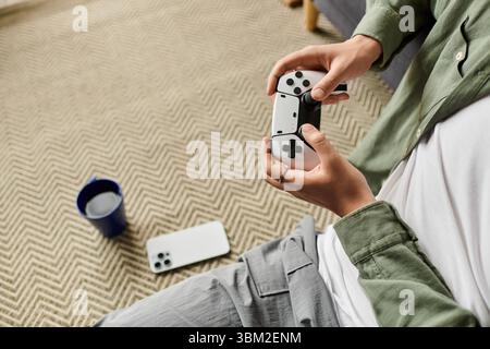 A young handsome man enjoys an immersive gaming session in his cozy living room. Stock Photo