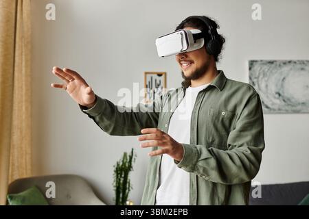 Handsome young man interacts with virtual reality in the comfort of his home. Stock Photo