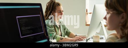 Young Adult Caucasian Woman Writing Neural Network Code on Desktop Computer Stock Photo