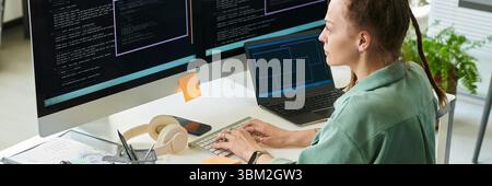 Young Adult Caucasian Woman Writing Neural Network Code on Dual Computer Screens Stock Photo
