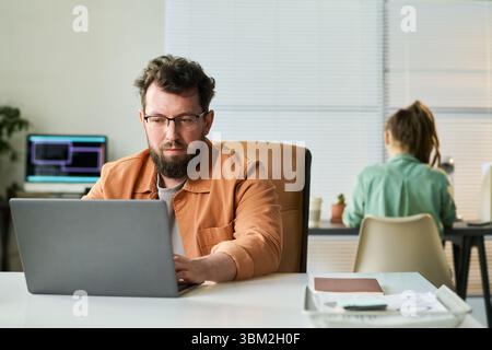 Caucasian Middle Aged Man Coding Neural Network Algorithm in Shared Workspace Stock Photo