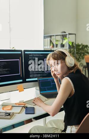 Portrait of Young Caucasian Woman Developing Neural Network on Computer Stock Photo