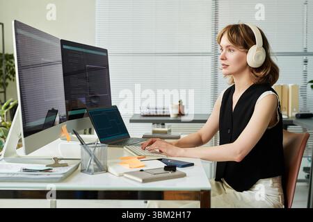 Young Adult Caucasian Woman Wearing Headphones Programming Neural Network Model Stock Photo