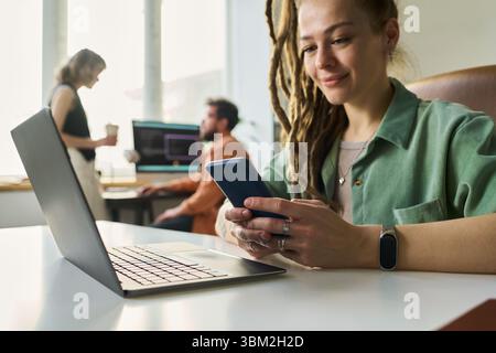 Woman Developing Neural Network Using Laptop and Smartphone Stock Photo