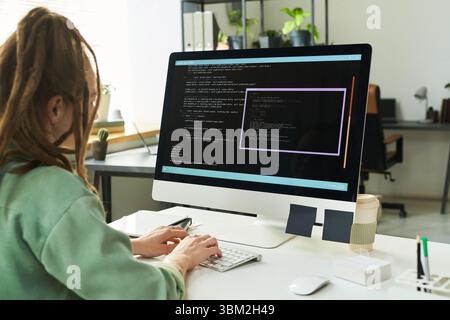 Young Adult Caucasian Woman Developing Neural Network Code on Computer Stock Photo