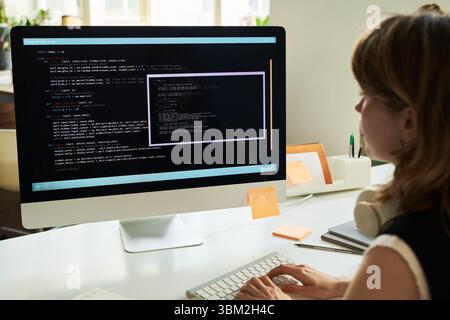 Young Caucasian Woman Developing Neural Network Code on Desktop Computer Stock Photo