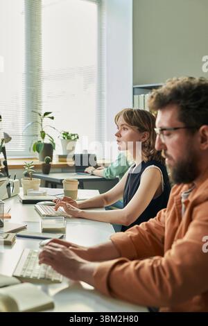 Young Caucasian Woman and Man Developing Neural Network on Computer in Office Stock Photo
