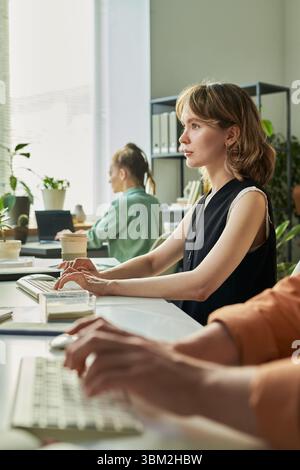 Young Caucasian Woman Developing Neural Network Model on Computer in Office Stock Photo