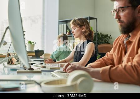 Young Caucasian Woman Developing Neural Network with Colleagues in Office Stock Photo