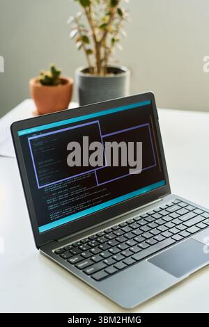 Laptop Displaying Neural Network Development Code Running on Screen Indoors Stock Photo