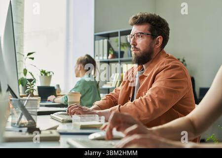 Caucasian Young Adult Man Developing Neural Network at Computer in Office Stock Photo