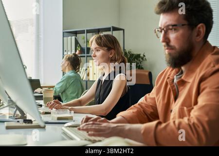 Young Caucasian Woman and Colleagues Developing Neural Network at Workplace Stock Photo