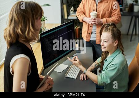 Young Caucasian Woman Explaining Neural Network Development to Colleagues Stock Photo