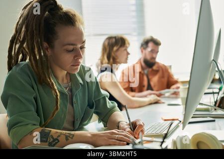 Young Caucasian Woman Developing Neural Network at Computer in Office Setting Stock Photo