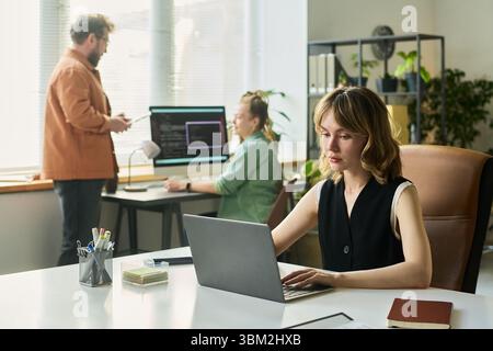 Young Caucasian Woman Developing Neural Network with Diverse Team in Office Stock Photo