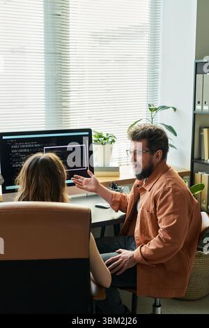 Caucasian Young Adult Man Explaining Neural Network Development to Woman Stock Photo