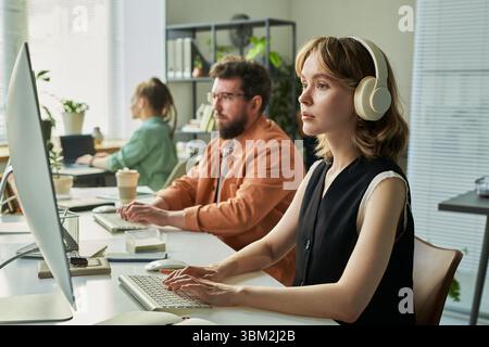 Young Caucasian Woman Developing Neural Network Software in Modern Office Stock Photo