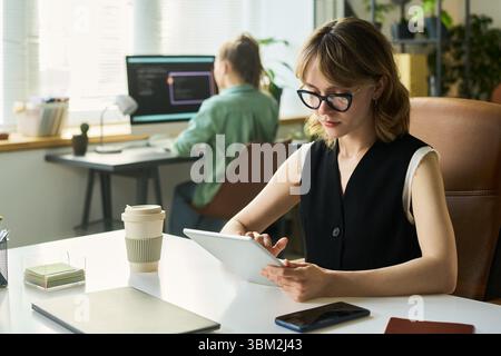 Young Caucasian Woman Using Digital Tablet While Developing Neural Network Stock Photo