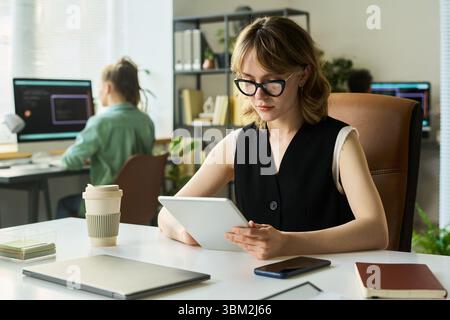 Young Caucasian Woman Developing Neural Network Using Digital Tablet in Office Stock Photo