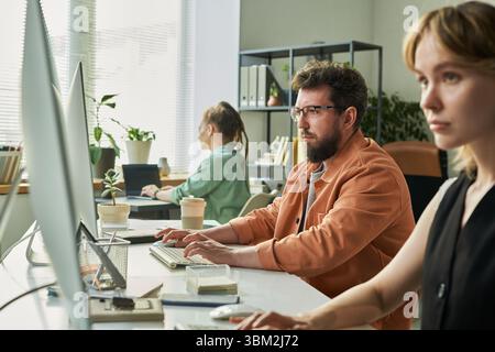 Young Caucasian Man and Woman Developing Neural Network in Modern Office Stock Photo