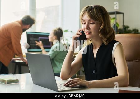 Young Caucasian Woman Developing Neural Network While Talking on Smartphone Stock Photo