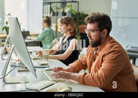 Caucasian Man Developing Neural Network with Colleagues in Office Stock Photo