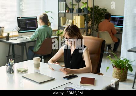 Young Caucasian Woman Developing Neural Network Algorithm on Digital Tablet Stock Photo