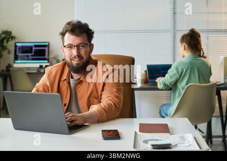 Portrait of Young Adult Caucasian Man Developing Neural Network on Laptop Stock Photo